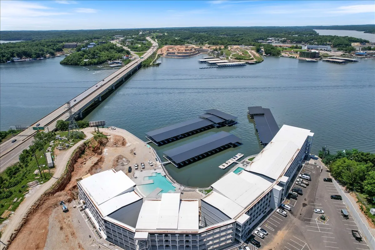 This image features the marina with prominent docks, calm waters, a bridge in the background, and surrounding buildings. The view beautifully showcases the lake's boating activity and places visitors directly at the water's edge, with boats moored and ready for adventures.