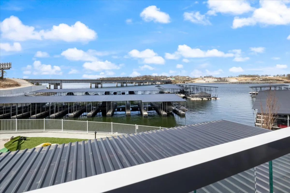 A tranquil view of the marina docks with calm water and blue sky, perfect for boating, fishing, or simply relaxing by the water’s edge. The grassy areas offer spots for picnics or peaceful reflection, connecting the property to the allure of the lake.